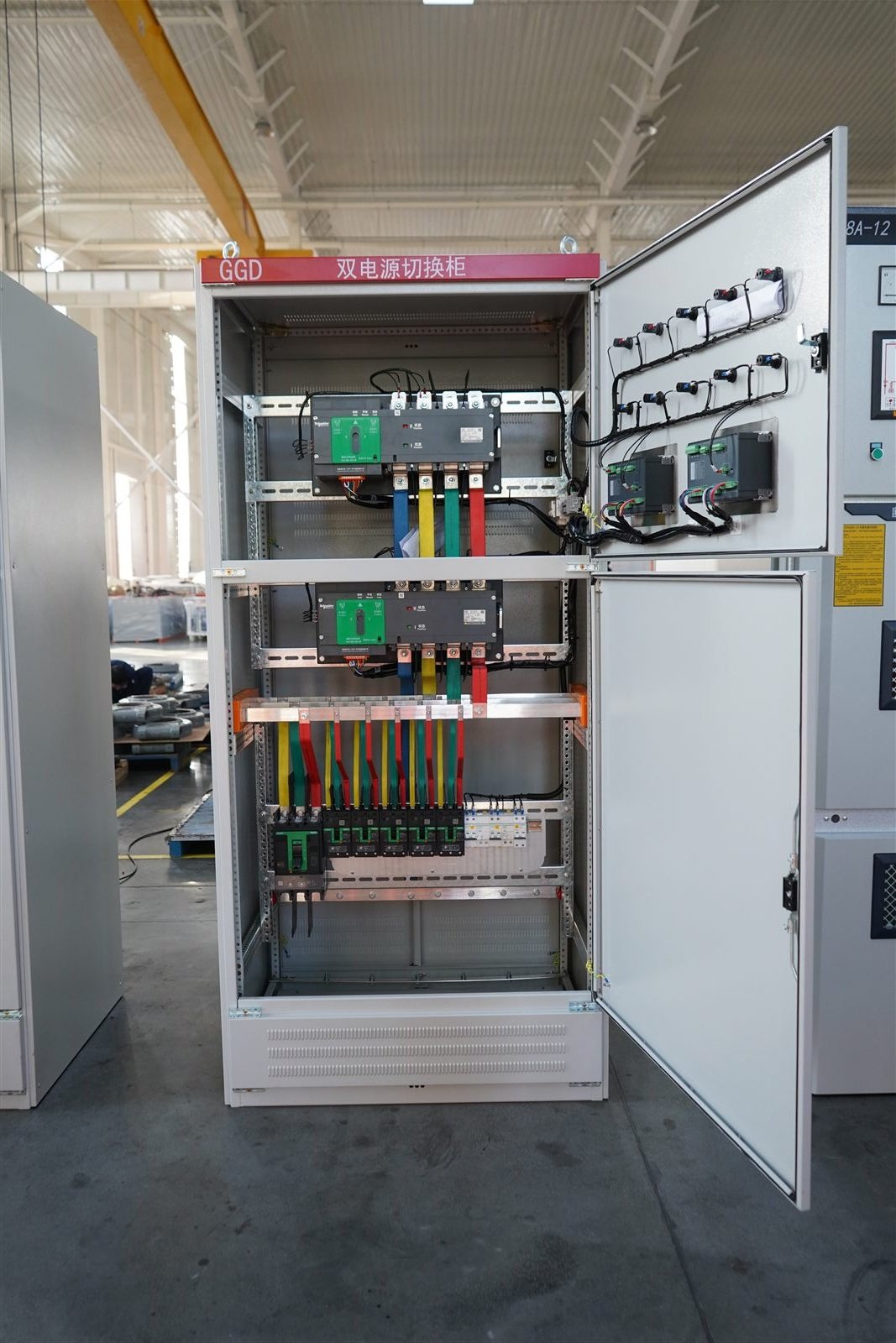 Automatic transfer switch cabinet interior showing transfer mechanism, busbars, controller and wiring